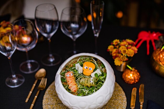 a bowl of food with a carrot on it sits on a table with other dishes