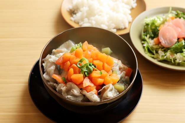 a bowl of food with rice and vegetables on a table