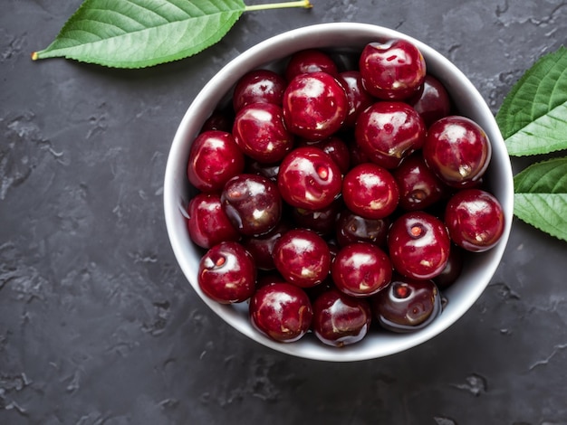 bowl of fresh cherry with leaves on a dark background