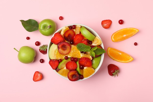 Bowl of fresh fruit salad on pink