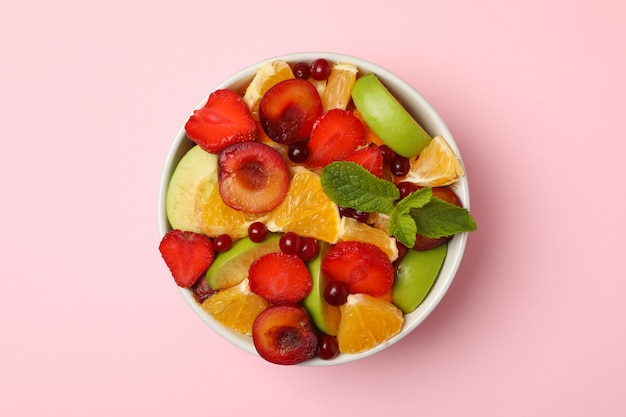 Bowl of fresh fruit salad on pink