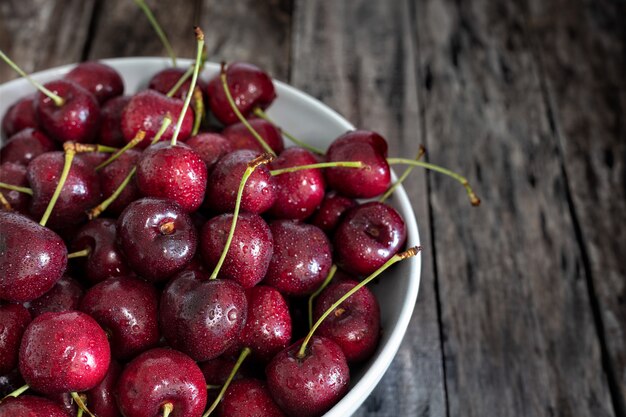 Bowl of fresh red cherries on wooden 