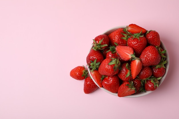 Bowl of fresh strawberry on pink surface