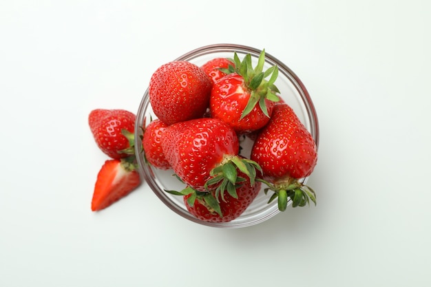 Bowl of fresh strawberry on white surface