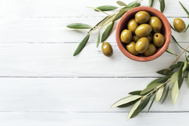 Bowl of Green Olives on a Rustic White Wooden Table With Olive Branches