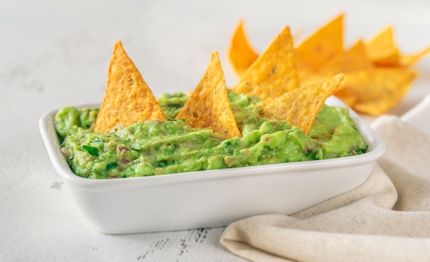 Bowl of guacamole with tortilla chips on the table