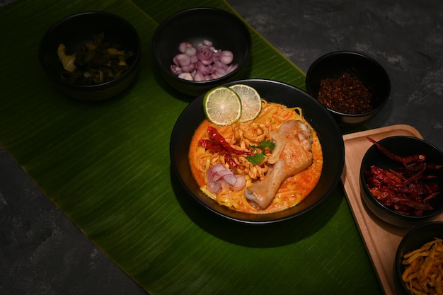 A bowl of Khao Soi Kai or creamy spicy yellow curry with chicken drumstick