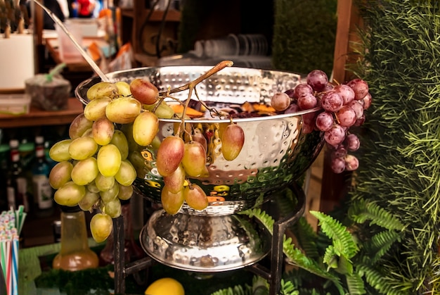 A bowl of mulled wine garnished with a bunch of grapes for a MidAutumn Festival