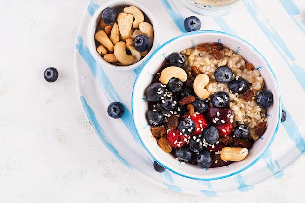 Bowl of oatmeal porridge with  berries and nuts Top view Clean eating