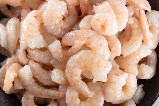 A bowl of peeled fresh raw white shrimp with tail