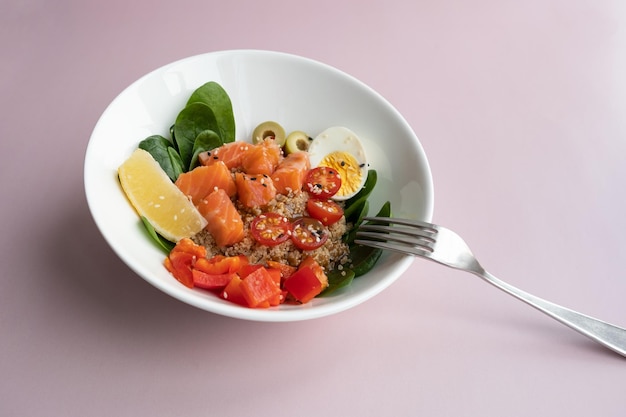 Bowl plate with poke dish fresh salmon quinoa spinach lemon for a healthy diet copy space