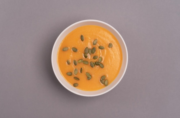 A bowl of pumpkin soup on a grey background Healthy food vegan food Top view flat lay