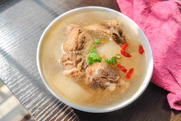 A bowl of radish rib soup on the table in the sun