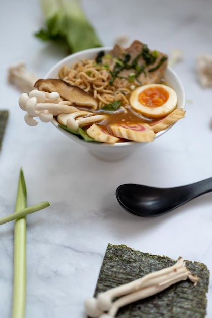 A bowl of ramen soup with all the ingredients over a marble table