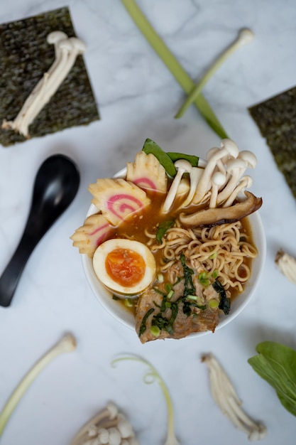 A bowl of ramen soup with all the ingredients over a marble table