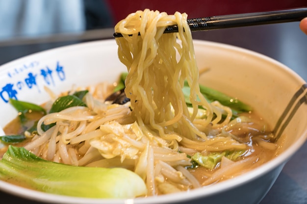 A bowl of ramen with chopsticks and a sign that says'ramen'on it