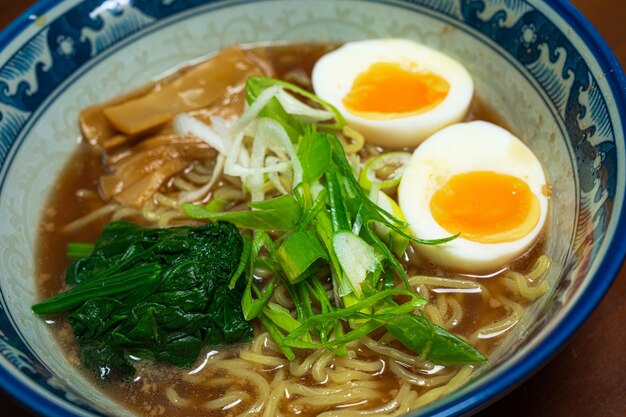 A bowl of ramen with a green leaf on top