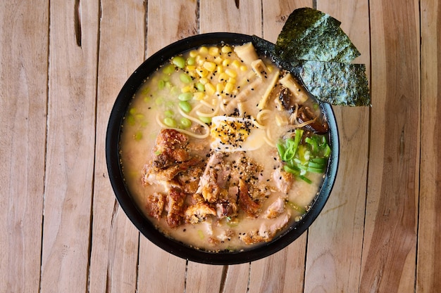 bowl of ramen with noodles on wooden surface