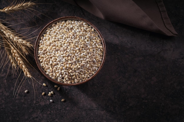 Bowl of raw dried broken pearl barley cereal grain