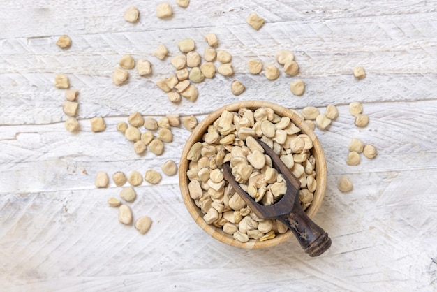 Bowl of raw dry Grass pea on wooden table top view Legumes known in Italy as Cicerchia