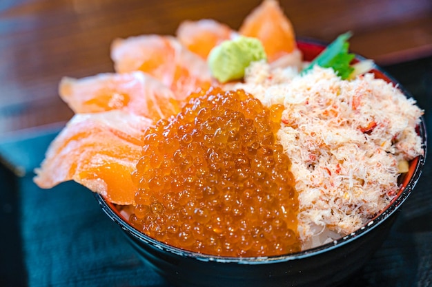 A bowl of red caviar sits on a table.