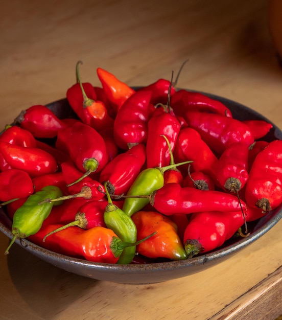 a bowl of red peppers with a black bowl of red peppers