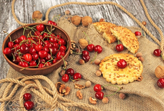 Bowl of ripe cherries and cookies with nuts