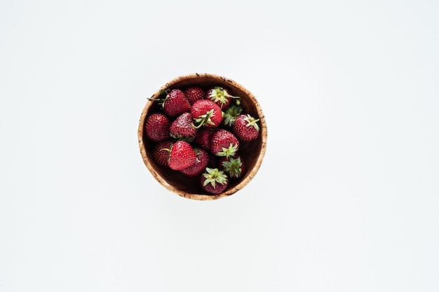 Bowl of ripe strawberries on white surface