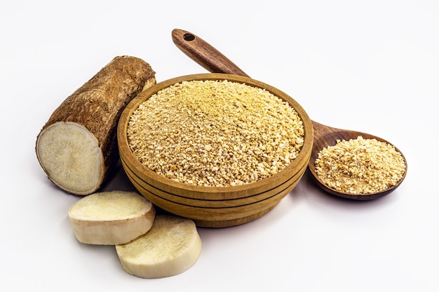 Bowl of roasted manioc flour on isolated white surface, alternative organic flour