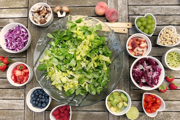 Photo a bowl of salad with a bowl of fruit and vegetables