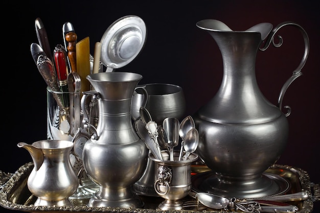 A bowl of silverware is on a table with a silverware container.