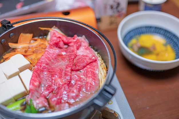 A bowl of soup with beef and vegetables on it