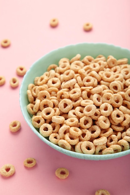 Bowl of sugarcoated corn flakes on pink background