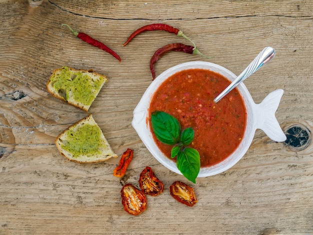 Bowl of tomato soup on a wooden table