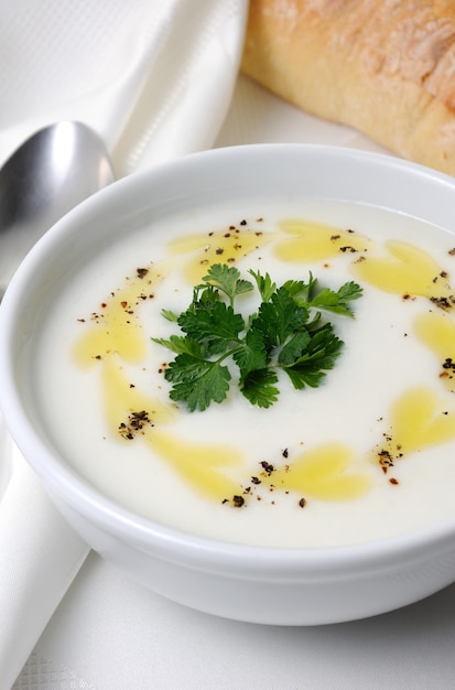 A bowl of white bean puree soup with spicy butter and spices, herb