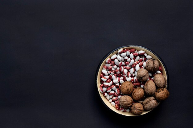 bowl with beans and nuts on black background