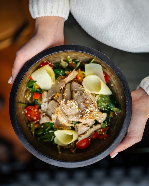 Bowl with beef salad with vegetables and cheese