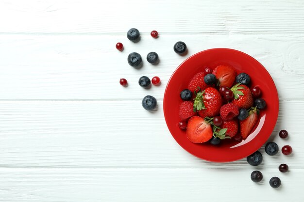 Bowl with berry mix on white wooden