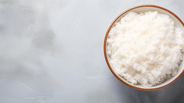 Bowl with boiled rice on grey background top view Space for text