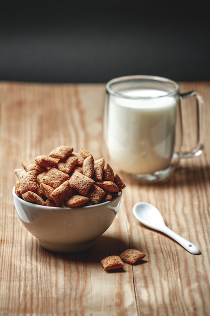 Bowl with chocolate quick breakfast cereal and glass of milk