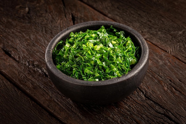 Bowl with chopped green cabbage sauteed in olive oil and garlic.