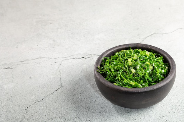 Bowl with chopped green cabbage sauteed in olive oil and garlic.