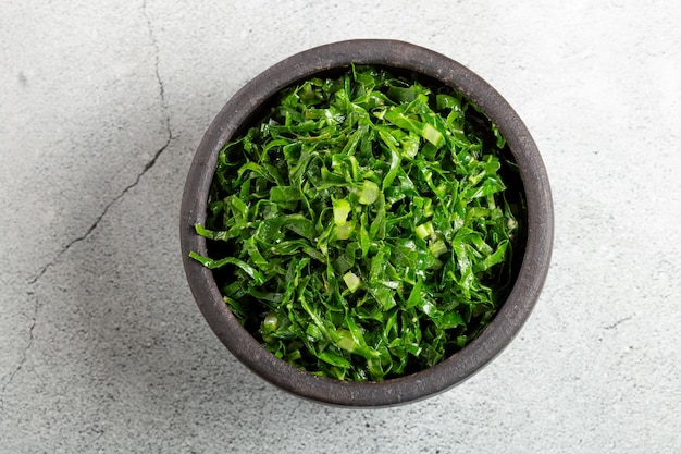 Bowl with chopped green cabbage sauteed in olive oil and garlic.