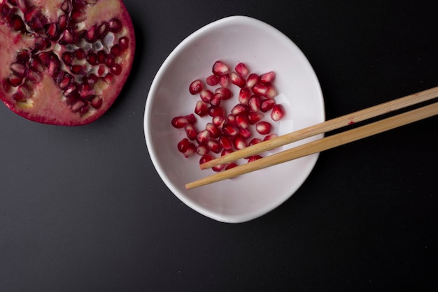 Bowl with chopsticks to eat pomegranate seeds