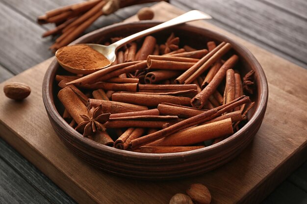 Bowl with cinnamon sticks on wooden table