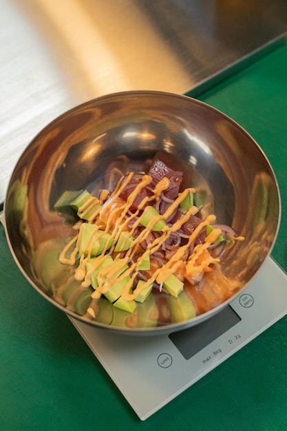 Bowl with fresh avocado salad on kitchen scale