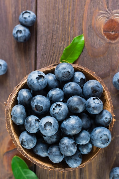 Bowl with fresh blueberries on a wooden table antioxidant organic healthy food top and vertical