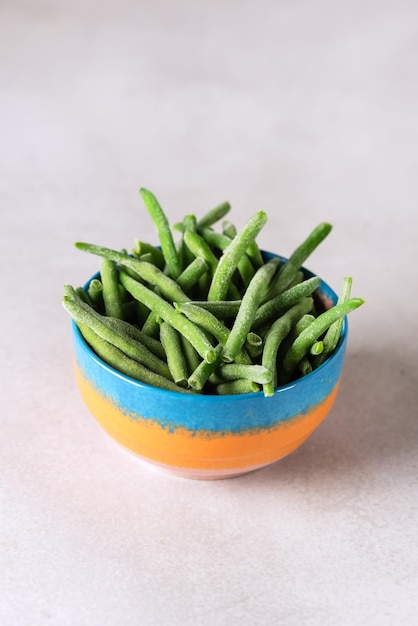 Photo bowl with frozen green beans on gray background healthy vegan food vertical