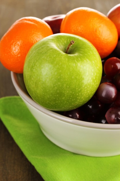 Bowl with fruits on wooden table