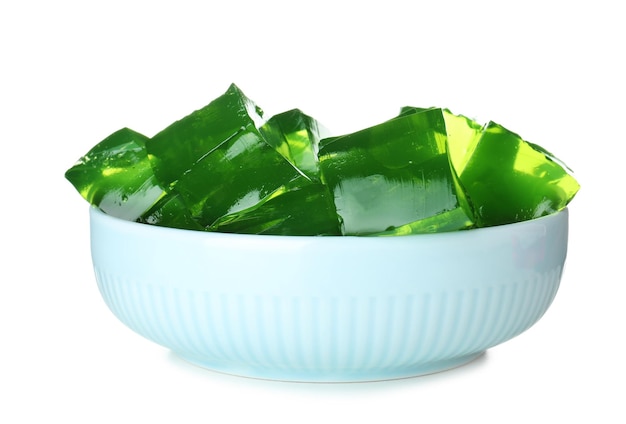 Bowl with green jelly cubes on white background